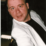 A man in a white jacket with a white hat.