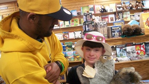 A man in a yellow hat is holding a stuffed animal.