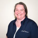 A smiling woman in a blue shirt.