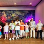 A group of people standing in front of a mural.