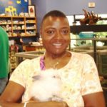 A woman holding a white bunny in a store.