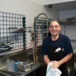 A special needs man wearing an apron.