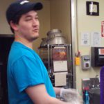 A man in supported employment wearing a blue shirt.