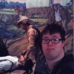 Slefie of a man near a poster
