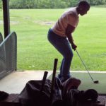 A man and a woman playing golf on a putting green.