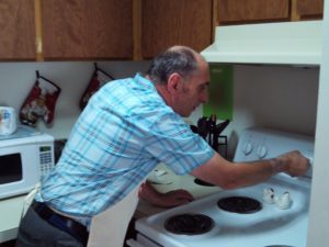 Dennis baking in his kitchen - residential living services