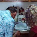 A man and a woman in a residential kitchen.