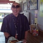 A man holding a hot dog in foil.