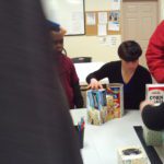 A group of people standing around a table.