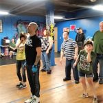 A man teaching dance to small children