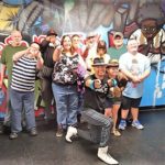 People posing in front of colorful graffiti mural