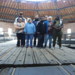 Group standing on wooden platform inside round rotunda