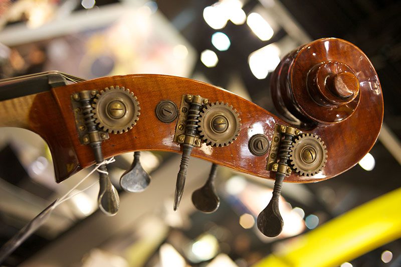 A close up of a violin with gears on it.